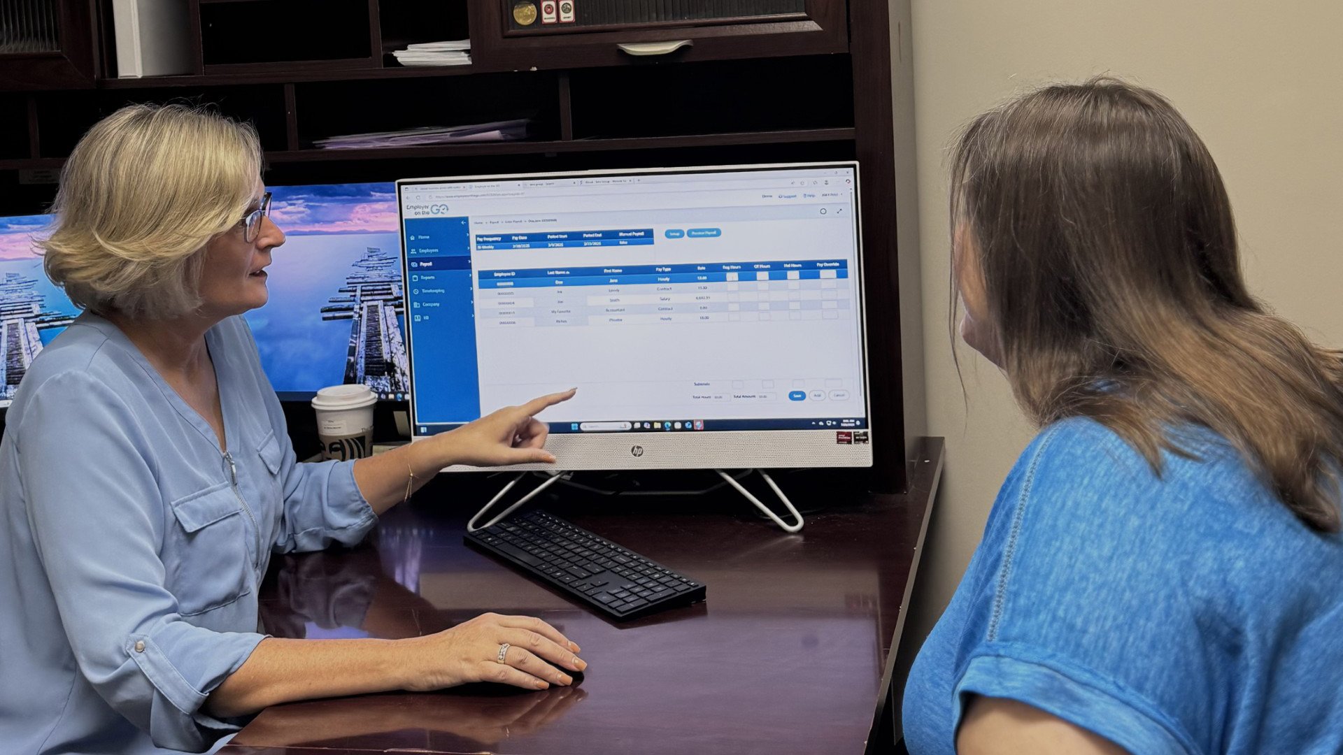 Payroll specialist in La Porte Indiana reviewing employee pay rates and hours with client using Absolute Wages software Payroll specialist in La Porte Indiana reviewing employee pay rates and hours with client using Absolute Wages software