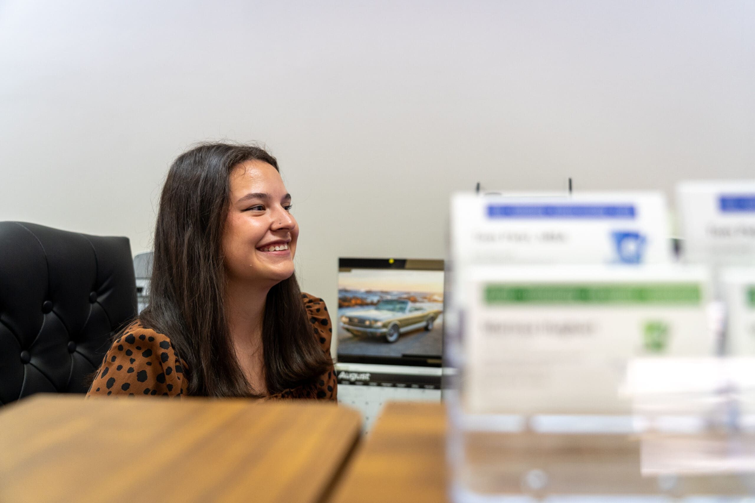 Team member smiling at her desk inside Petri Financial Services Team member smiling at her desk inside Petri Financial Services